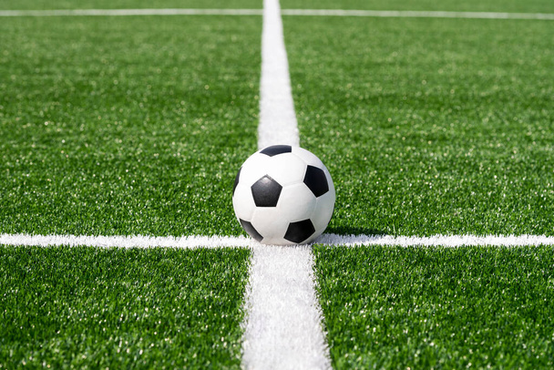 Fútbol blanco y negro y pelota de fútbol en el campo. Cartel de tema deportivo horizontal, tarjetas de felicitación, encabezados, sitio web y aplicación - Foto, imagen