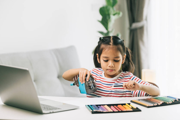 Nettes kleines asiatisches Mädchen mit Laptop zu Hause. Bildungskonzept. - Foto, Bild