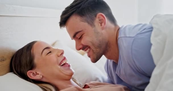 Γελάστε, χαλαρώστε και κάντε ζευγάρια στο κρεβάτι για δέσιμο, συζήτηση ή επικοινωνία. Φιλί, αγάπη και νεαρός άνδρας και γυναίκα που μιλούν με κόμικ, κωμωδία και αστείο αστείο μαζί στην κρεβατοκάμαρα στο σπίτι - Πλάνα, βίντεο