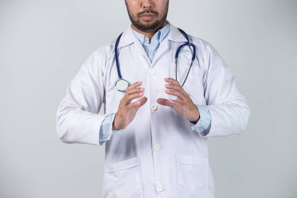 Mieslääkäri stetoskooppi kaulassaan, eristetty harmaalla pohjalla - Valokuva, kuva