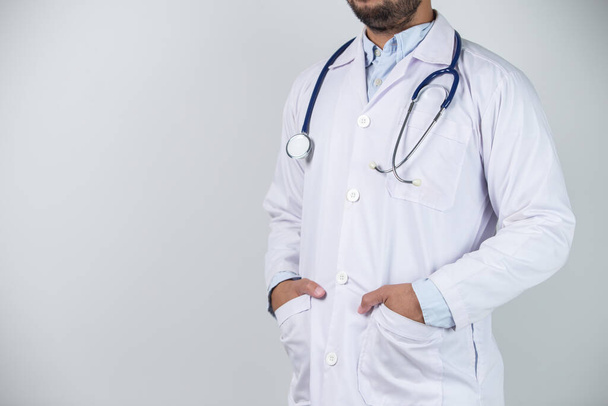 Ασιάτης με στολή γιατρού σε λευκό φόντο στο νοσοκομείο - Φωτογραφία, εικόνα