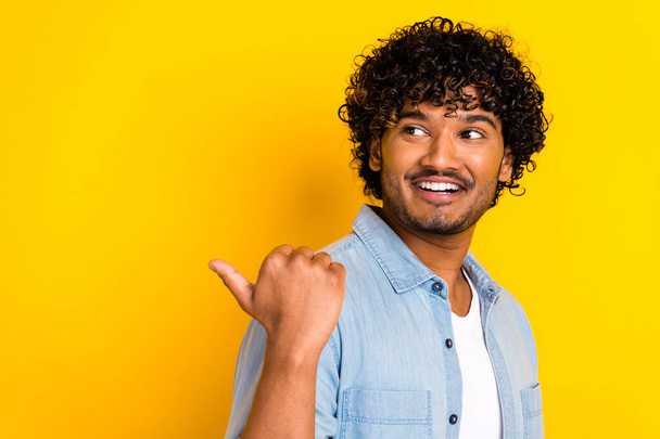 Portré vonzó pozitív ember fogas mosoly néz közvetlen ujj üres tér elszigetelt sárga színű háttér. - Fotó, kép