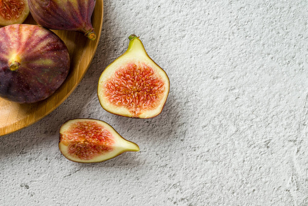 View of whole and cut organic figs on stone table - Photo, Image