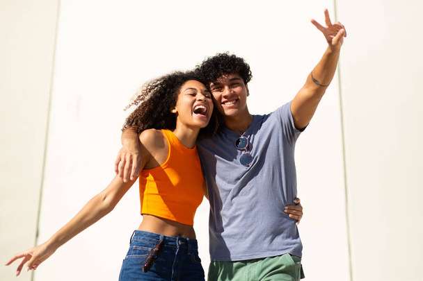 Portrait of cheerful young couple by white wall - Foto, Imagem