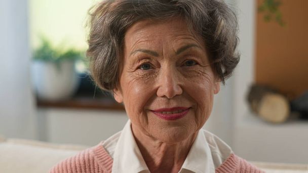 Headshot pensive grandmother senior woman looking distance away turn to camera old mature female elderly granny indoors at home smiling happy portrait older grey-haired healthy cheerful retired lady - Foto, afbeelding