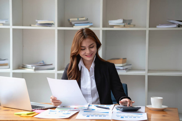 accountant, Auditor, Self-Employed, Finance and Investment, tax calculation and budget, Portrait of Asian female entrepreneur using a calculator to calculate. Company business results document - Photo, Image