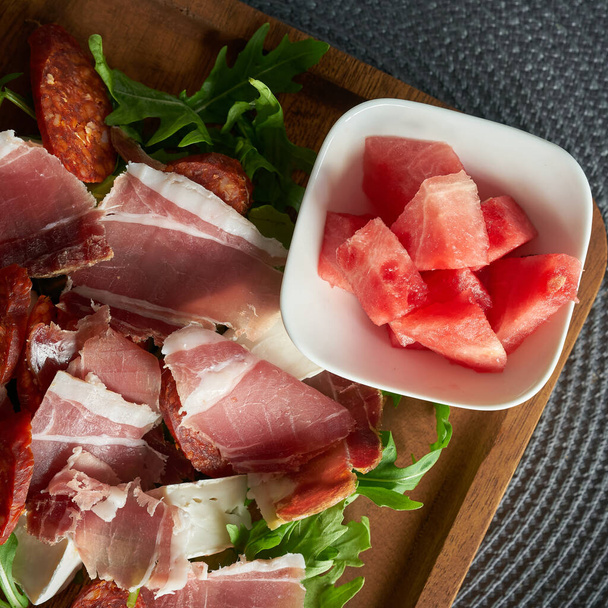   lanche saudável em um restaurante na Itália com presunto, salame, foguete e queijo e uma tigela de melão                              - Foto, Imagem