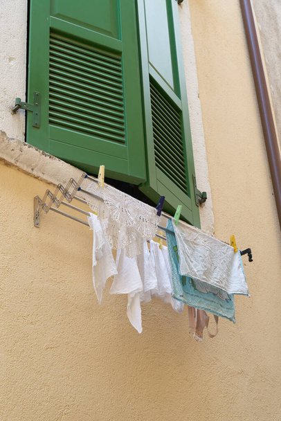 イタリアのガルダ湖のリモン・サルダールの古い町の家の窓に洗濯を掛ける                                - 写真・画像