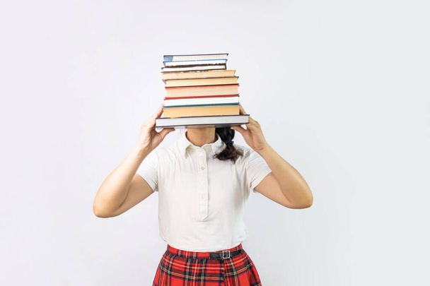 Dívka drží hromadu knih na bílém pozadí. Vzdělávací koncept. Připraven tvrdě studovat! - Fotografie, Obrázek