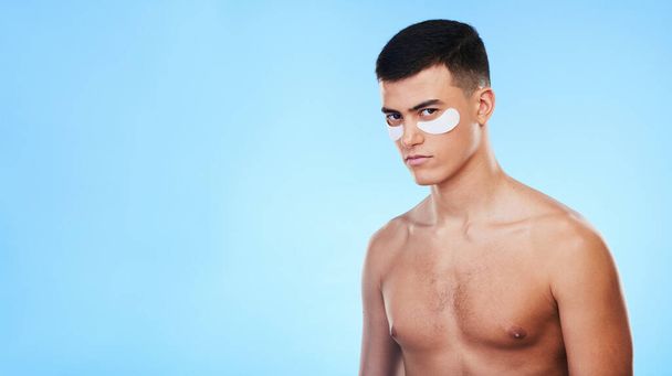 Man, beauty and banner with eye patch for skincare, grooming and clean with hygiene on blue background. Skin treatment, cosmetics product and mockup space, portrait and dermatology in a studio. - 写真・画像
