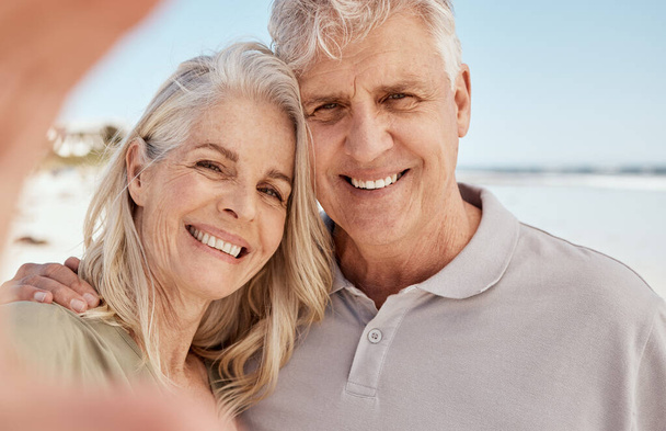 Old couple, selfie and smile in portrait on beach, love and travel with social media memory and wellness. Hug, smile in picture and trust, commitment and partner with marriage, retirement and holiday. - Foto, imagen