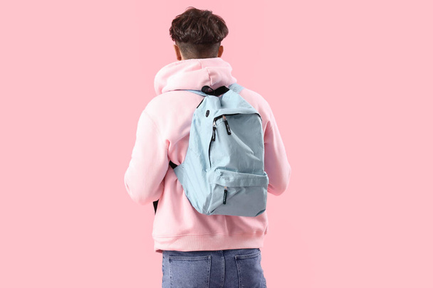 Чоловік студент з рюкзаком на рожевому тлі, вид ззаду - Фото, зображення