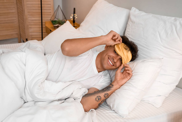 Jongeman met masker in bed - Foto, afbeelding
