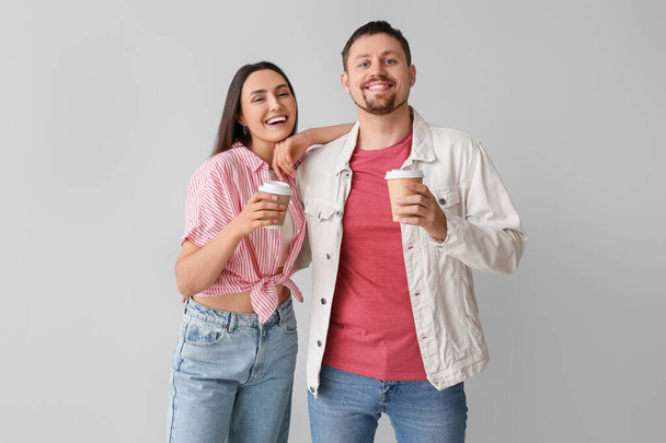 Hafif arka planda kahve fincanları olan mutlu genç çift. - Fotoğraf, Görsel