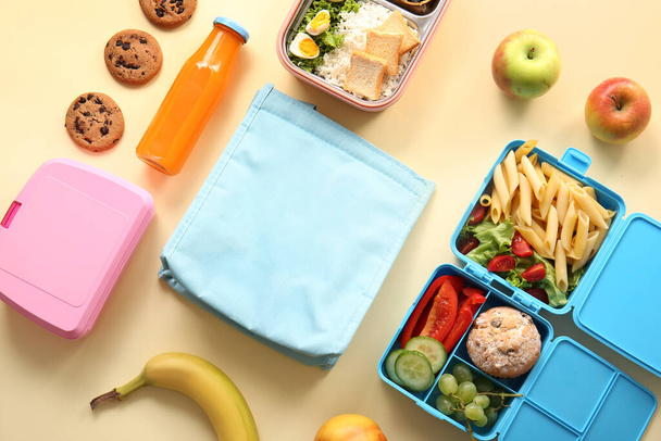 Borsa, cestini per il pranzo con cibo delizioso e bottiglia di succo su sfondo giallo - Foto, immagini