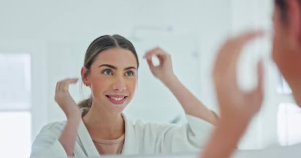 Morning, bathroom mirror and woman with hair or self care for natural beauty and happiness. Face of person with a smile for hairstyle, cosmetics and wellness or grooming routine at hotel, spa or home. - Filmagem, Vídeo