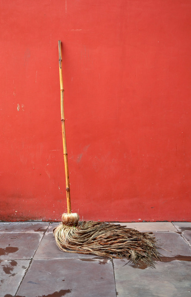 Mop lean against red wall - Photo, Image