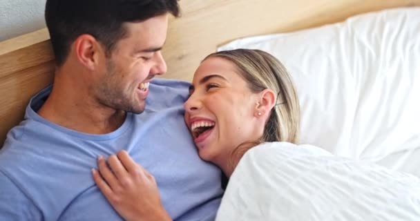 Love, bed and couple with a smile, relax and romantic with conversation, commitment and morning. People, man and happy woman with relationship, bedroom or loving together with trust, home or marriage. - Footage, Video