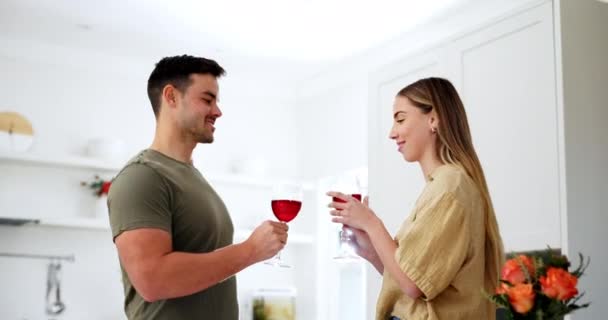 Пара на кухні з вином, вітає і цілує з посмішкою, щоб відсвяткувати любов, шлюб і щасливий дім. Тост з алкоголем в склі, чоловік і жінка на побаченні, розслабтеся для спілкування в квартирі разом - Кадри, відео