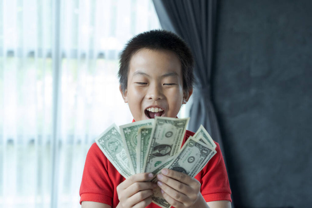 Překvapený chlapec držící peníze - Fotografie, Obrázek
