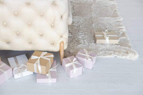 Прекрасні різдвяні подарункові коробки на підлозі біля ялинки в кімнаті
 - Фото, зображення