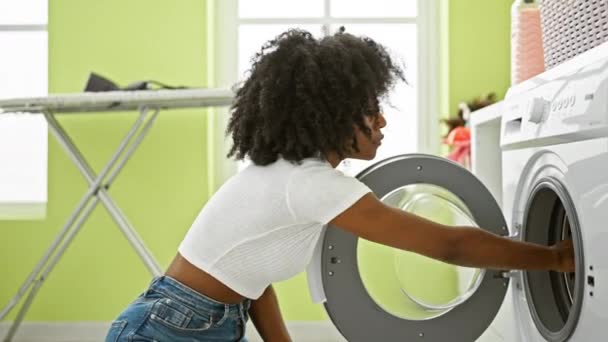 Mujer afroamericana lavando ropa oliendo calcetines sucios en la lavandería - Metraje, vídeo