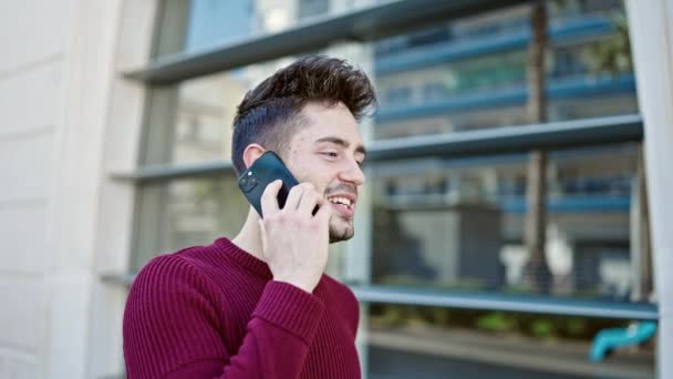 Jeune homme hispanique souriant confiant parler sur le smartphone à la rue - Séquence, vidéo