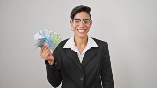Giovane bella donna ispanica imprenditore holding chilean pesos sorridente su isolato sfondo bianco - Filmati, video