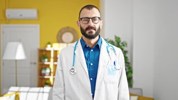 Junger hispanischer Arzt steht mit ernster Miene und sagt Nein mit Kopf in Klinik - Filmmaterial, Video