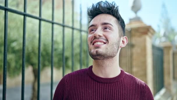 Jonge Spaanse man glimlacht vol vertrouwen op straat - Video