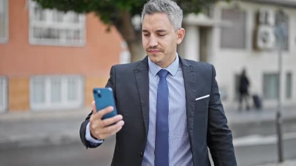 若いヒスパニックの男ビジネスワーカーは自信を持ってスマートフォンでセルフィーを作ります - 映像、動画