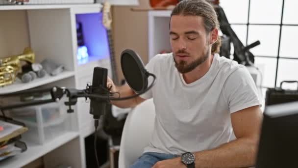 Joven músico hispano cantando canción en el estudio de música - Imágenes, Vídeo