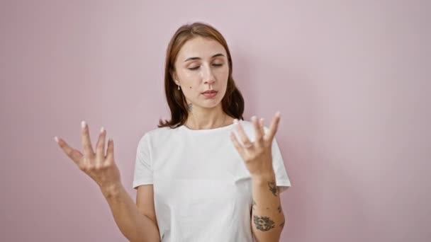 Mujer joven hablando sobre fondo rosa aislado - Metraje, vídeo
