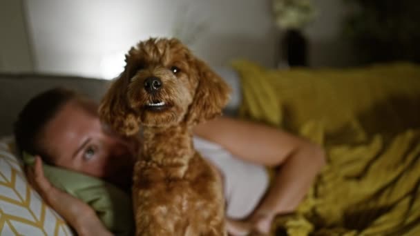 Jovem caucasiana com cão brincando deitado no sofá em casa - Filmagem, Vídeo