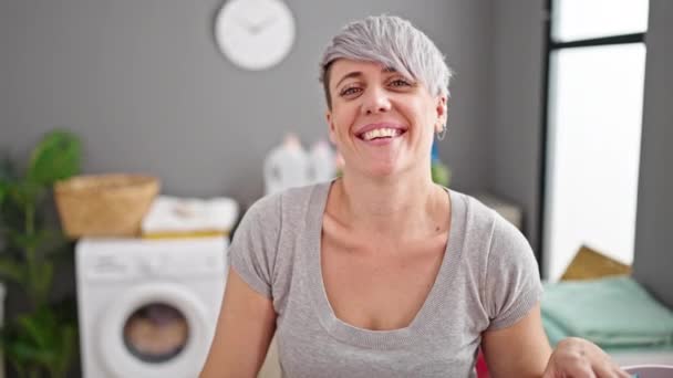 Mujer joven sonriendo confiada de pie en la lavandería - Imágenes, Vídeo