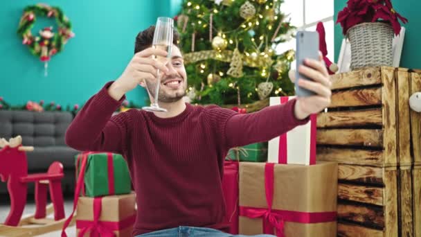 Jonge Spaanse man met videogesprek champagne drinken vieren kerst thuis - Video