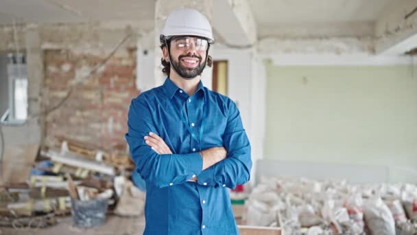 Молодой латиноамериканец архитектор улыбается уверенно делая большой палец вверх жестом на стройке - Кадры, видео