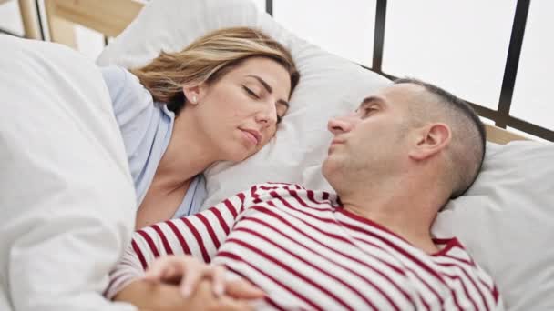 Erkek ve kadın çift yatakta uzanıp yatak odasında öpüşüyor ve uyuyor. - Video, Çekim