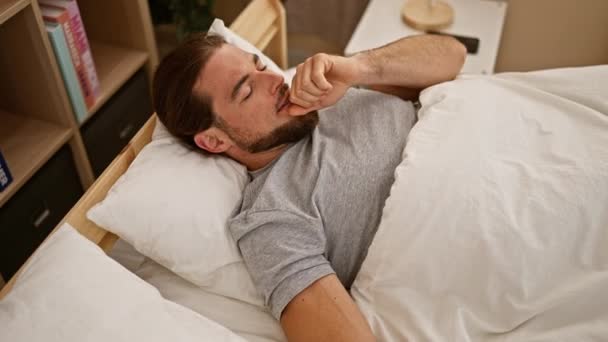 Giovane uomo ispanico che cerca di dormire tossendo in camera da letto - Filmati, video