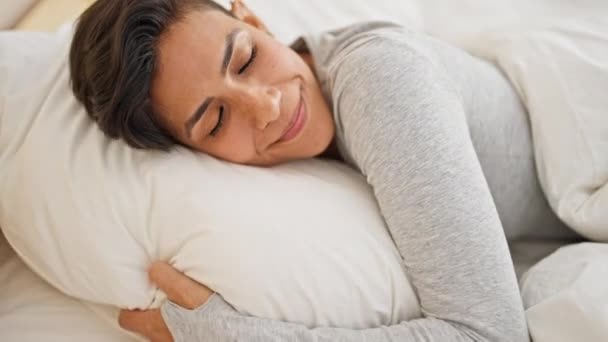 Nuori kaunis latino nainen makaa sängyllä nukkumassa makuuhuoneessa - Materiaali, video