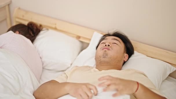 Férfiak és nők fekszenek az ágyon stresszelve a hálószobában - Felvétel, videó