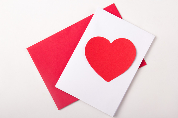 love concept - handmade card with red paper heart over white - Photo, image