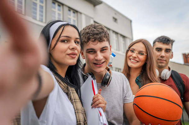 grupa nastolatków robić selfie autoportret przed szkoła uniwersytet mężczyzna i kobieta przyjaciele kaukaski mężczyzna kobieta nastolatki przed kampusem czekać na zajęcia z powrotem do koncepcji szkoły - Zdjęcie, obraz