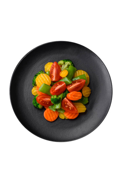 Σαλάτα με φρέσκα και αχνιστά λαχανικά ντοματίνια, μπρόκολο, καρότα και φασόλια σπαράγγια σε σκούρο σκυρόδεμα - Φωτογραφία, εικόνα