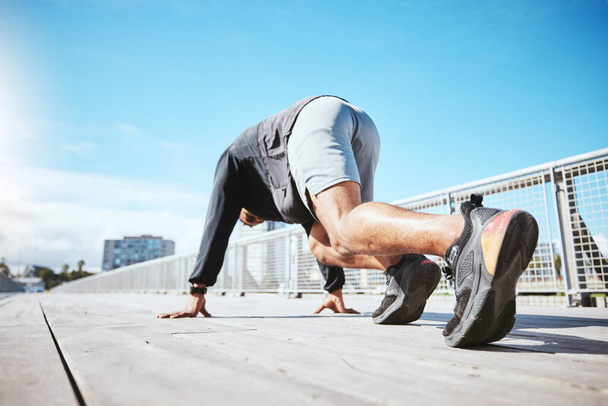 Άσκηση, τρέξιμο και την πλάτη ενός άνδρα στην αρχή της προπόνησης του στην πόλη για καρδιο ή προπόνηση αντοχής. Γυμναστήριο, γέφυρα και παπούτσια ενός άνδρα δρομέα ή αθλητή υπαίθρια για μια πρόκληση. - Φωτογραφία, εικόνα
