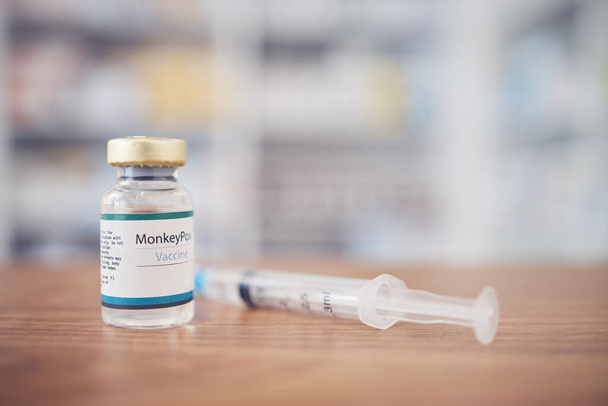 Background of monkeypox vaccine, bottle and injection for protection, safety and healthcare risk in clinic. Closeup, medicine vial and needle for immunity, medical antivirus and pharmaceutical drugs. - Photo, Image