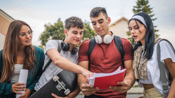 group of teenage students gen z study in front of school university male and female friends caucasian man and woman teenagers prepare exam in front of campus read learn back to school concept - Photo, Image