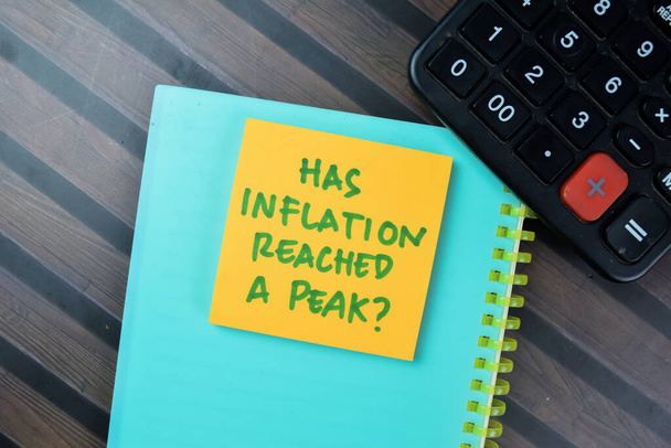 Концепция инфляции достигла пика? писать на бумажках, изолированных на столе Вудена. - Фото, изображение