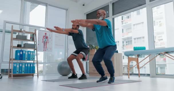 Černoši, squat a osobní trenér na fyzioterapii, cvičení nebo cvičení společně na klinice. Afričtí muži v těle zahřívají, zdravotní nebo fitness pro pilates, školení nebo zdraví a wellness. - Záběry, video
