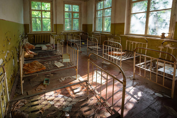 Tchernobyl, Ukraine - 06 août 2019 : Jardin d'enfants abandonné avec berceaux - Village de Kopachi, zone d'exclusion de Tchernobyl, Ukraine - Photo, image